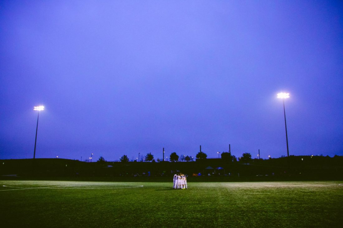 team huddle under floodlights